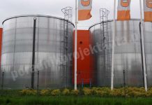 Zbiorniki przeciwpożarowe – Jak obliczyć czas napełniania wodą? Dwa naziemne stalowe zbiorniki zapasu wody do celów przeciwpożarowych przy centrum budowlanym